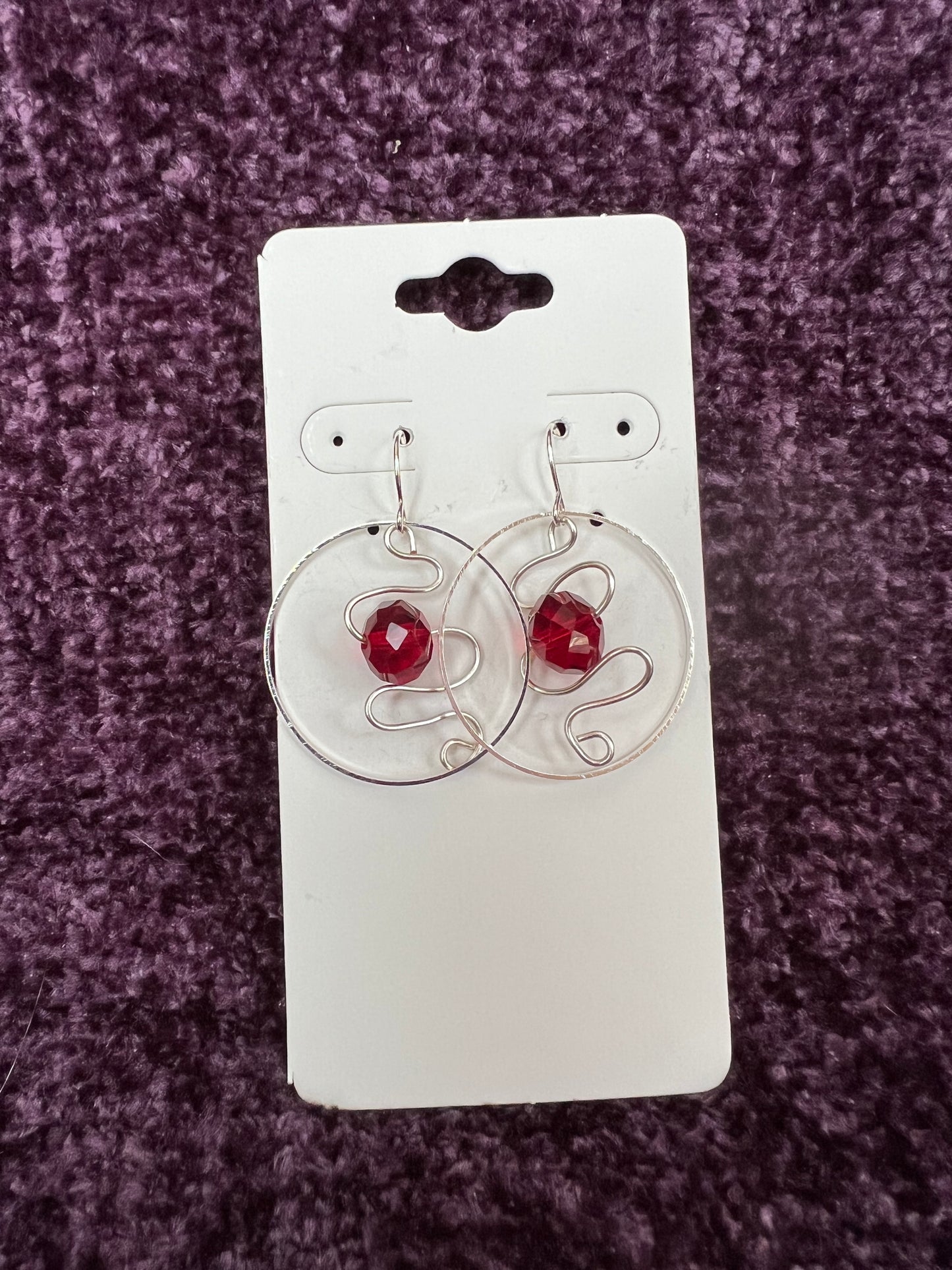 Earrings- Silver plated hoop with wire scroll design and red crystal.