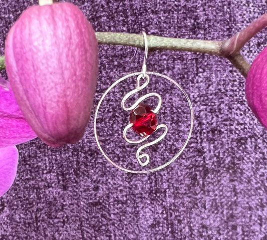 Earrings- Silver plated hoop with wire scroll design and red crystal.