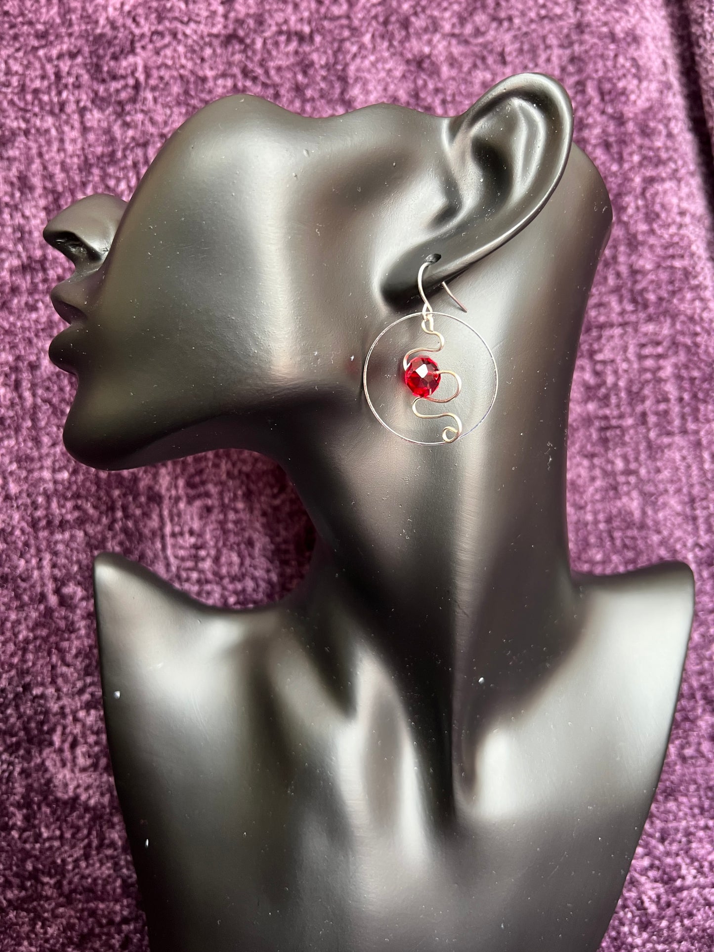 Earrings- Silver plated hoop with wire scroll design and red crystal.