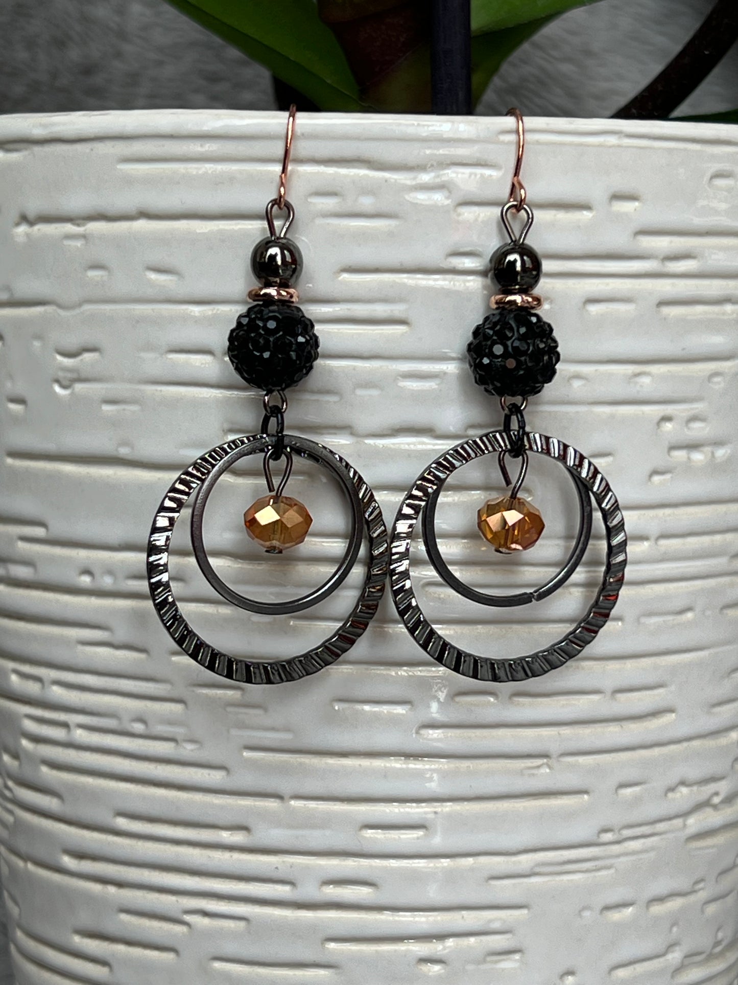 Earrings- Gun metal with copper plated ear wires & iridescent orange satin crystal.