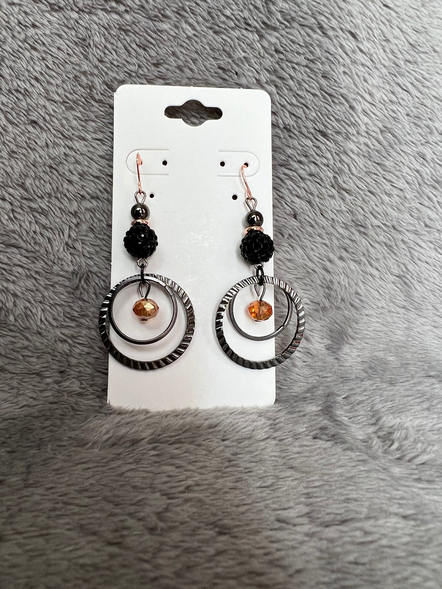 Earrings- Gun metal with copper plated ear wires & iridescent orange satin crystal.