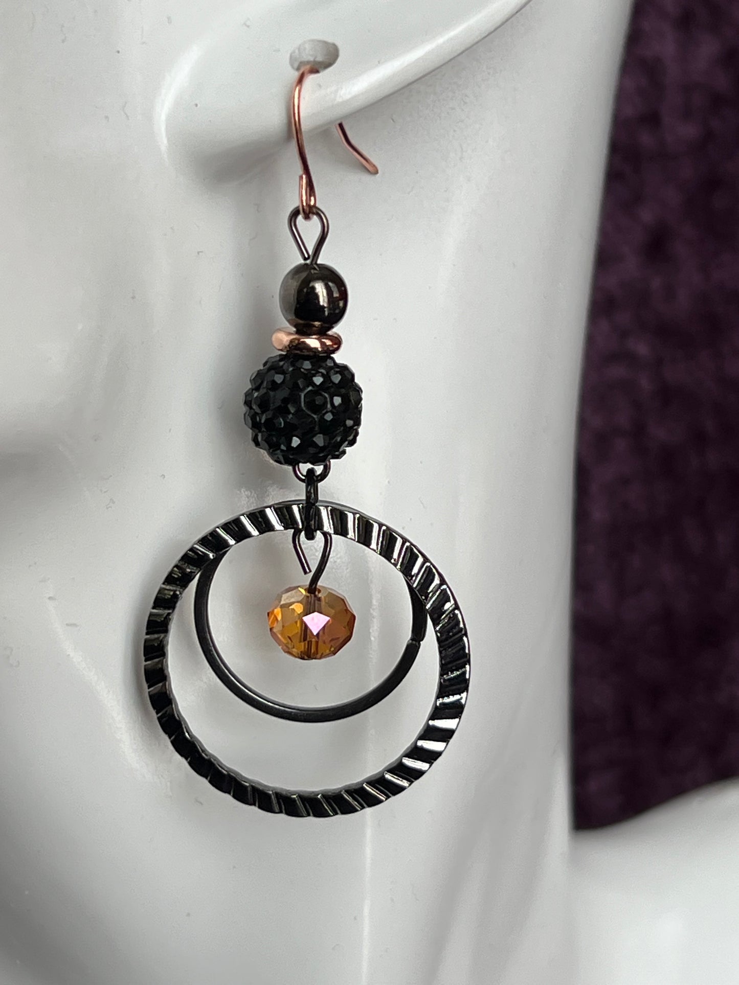 Earrings- Gun metal with copper plated ear wires & iridescent orange satin crystal.