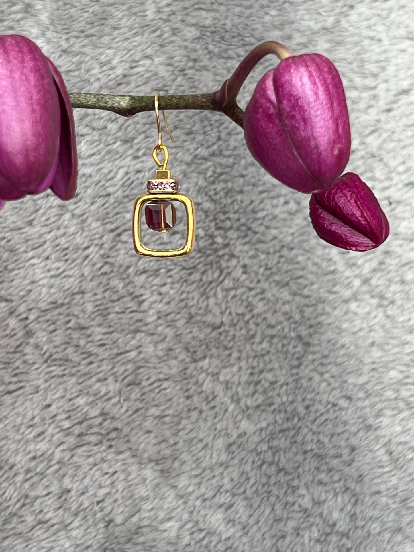 Earrings- Gold plated metal with purple crystal inside square.