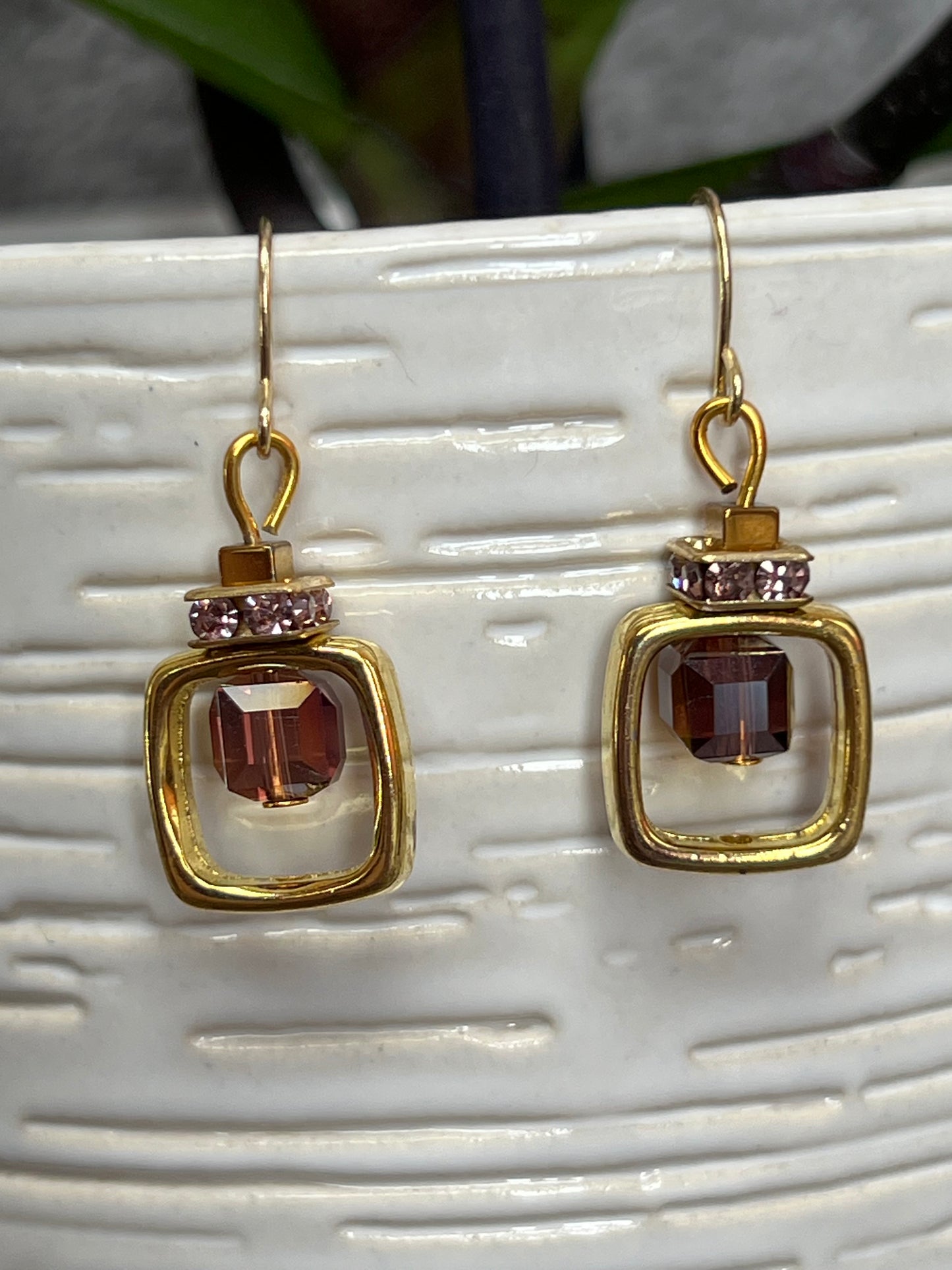 Earrings- Gold plated metal with purple crystal inside square.