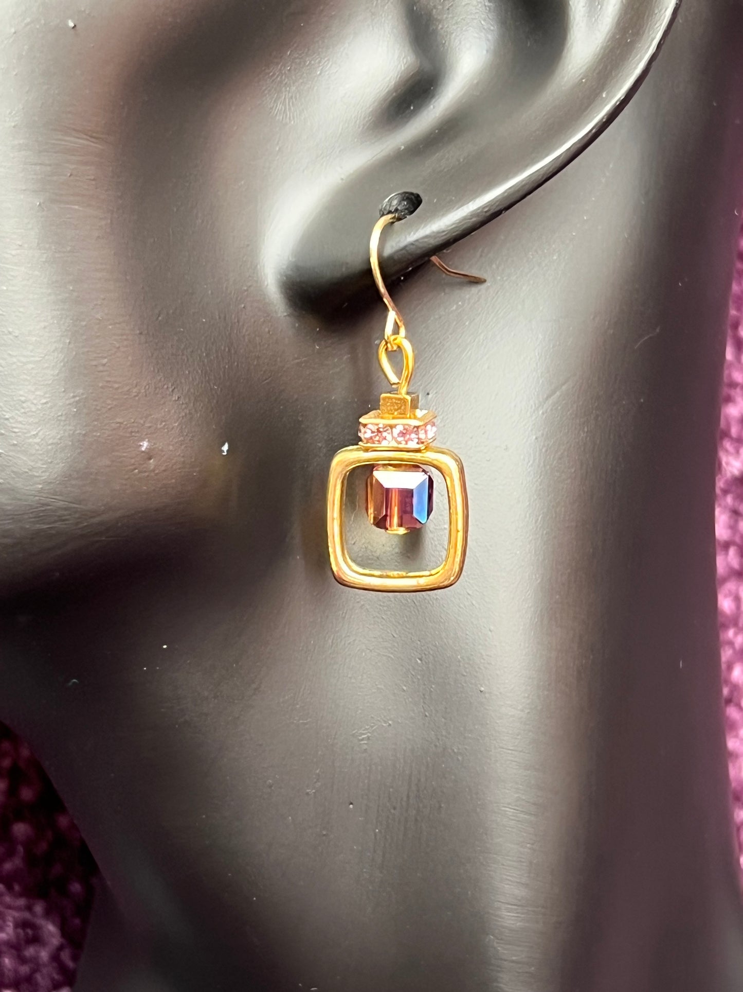 Earrings- Gold plated metal with purple crystal inside square.