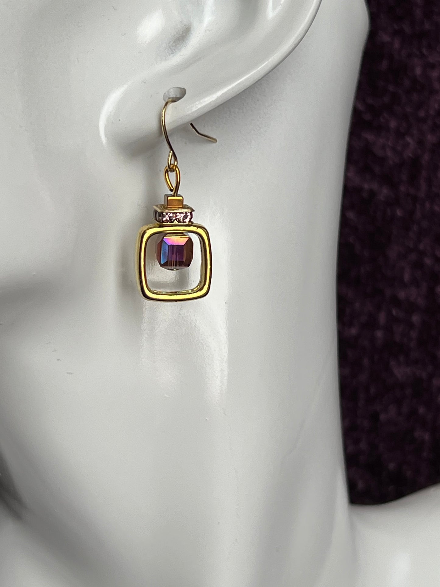 Earrings- Gold plated metal with purple crystal inside square.