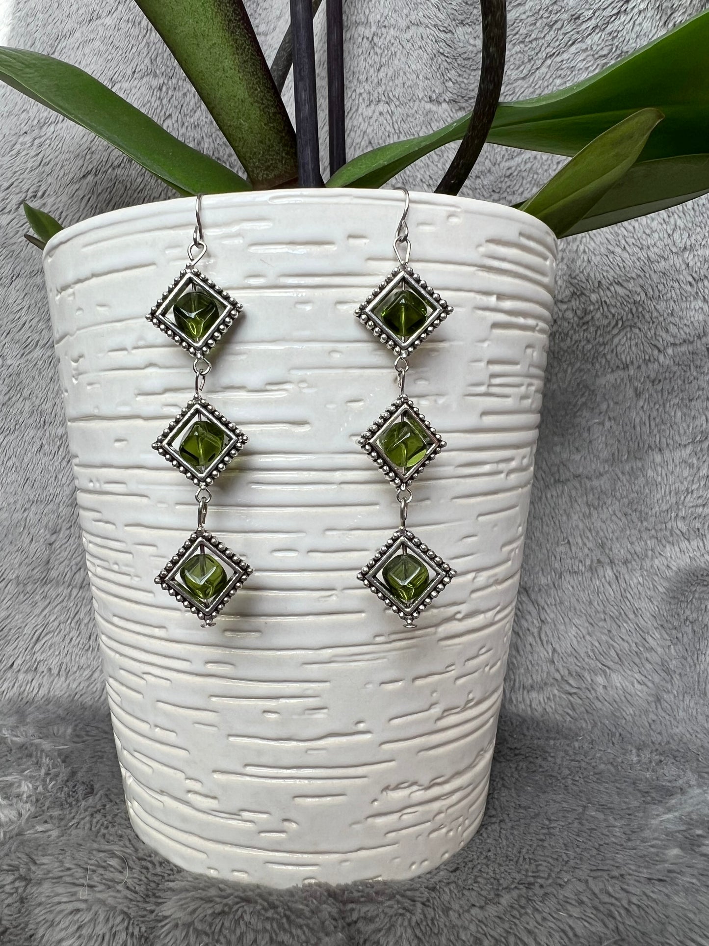 Earrings- Three tiered silver plated metal with olive colored glass beads