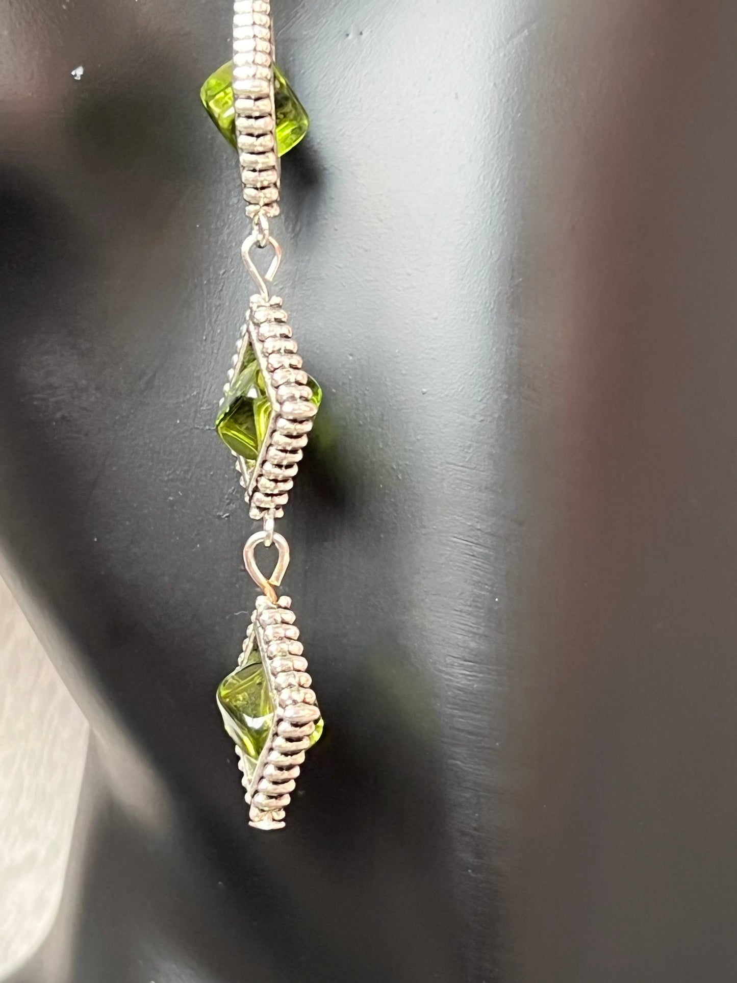 Earrings- Three tiered silver plated metal with olive colored glass beads