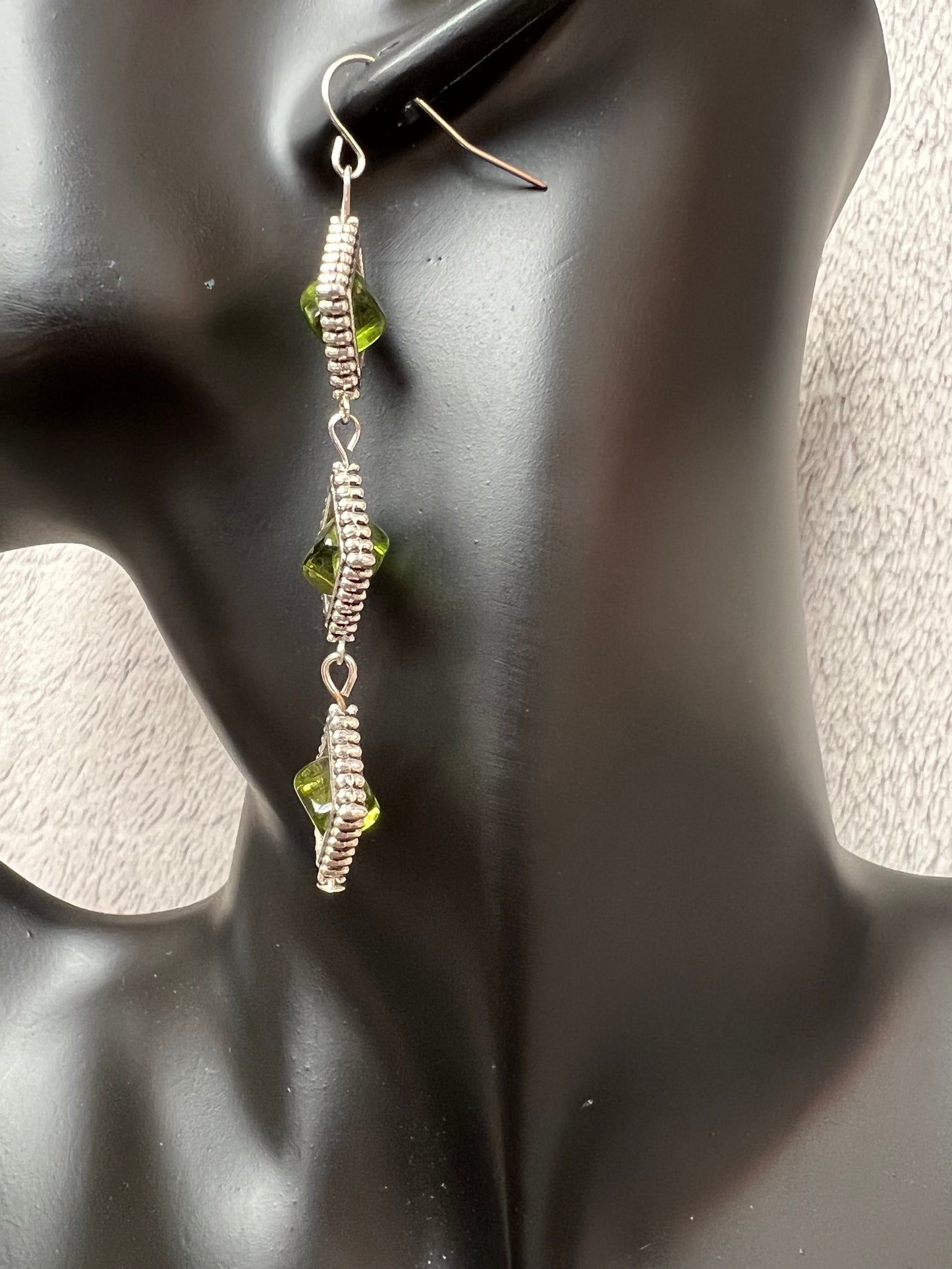 Earrings- Three tiered silver plated metal with olive colored glass beads