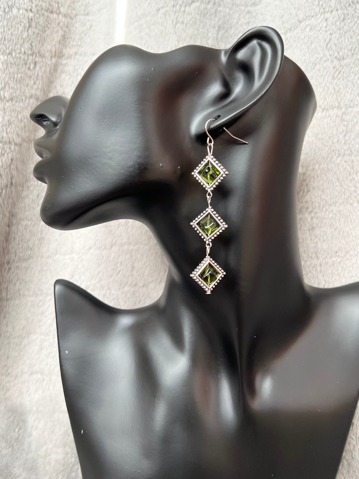 Earrings- Three tiered silver plated metal with olive colored glass beads