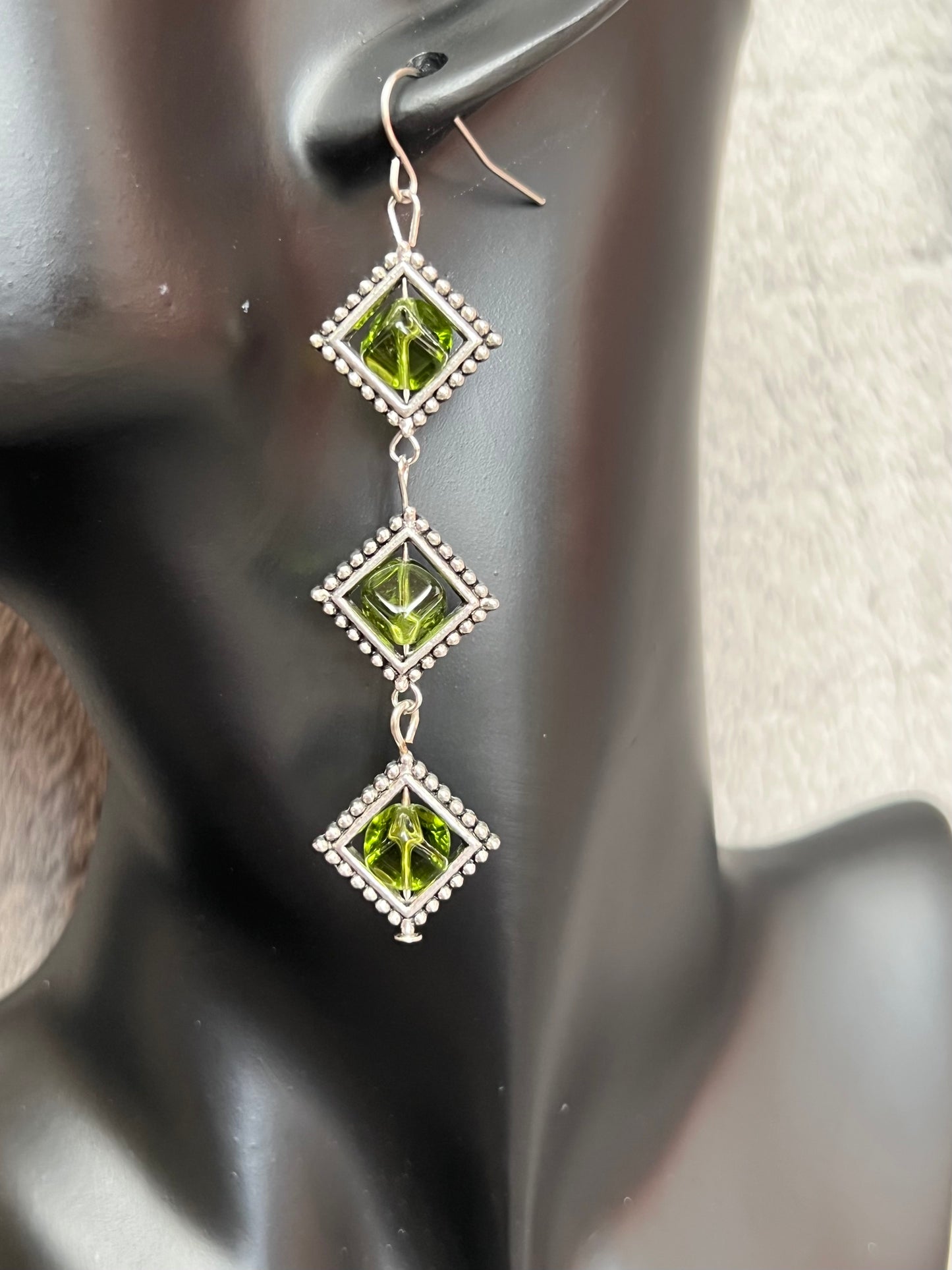 Earrings- Three tiered silver plated metal with olive colored glass beads