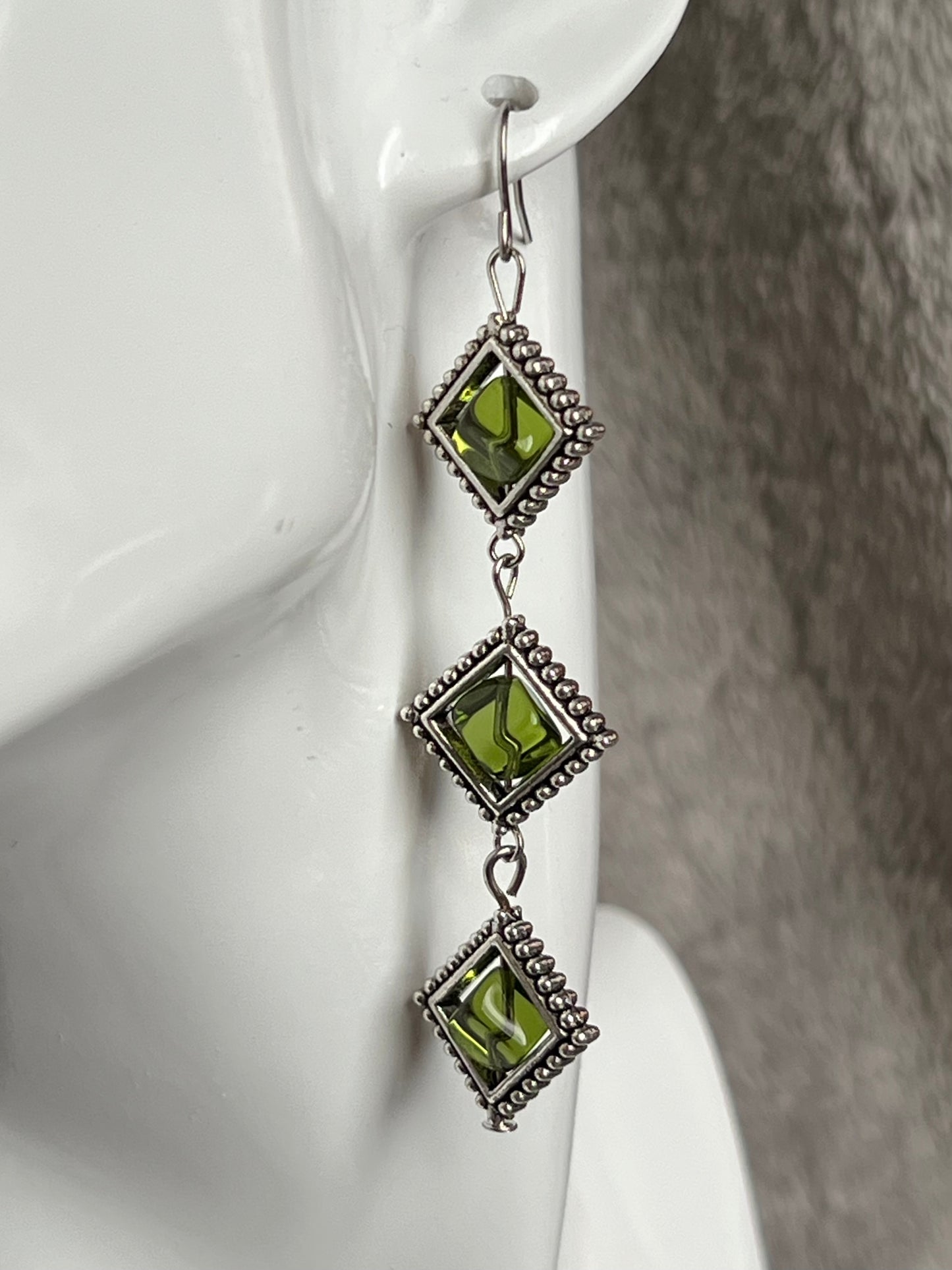 Earrings- Three tiered silver plated metal with olive colored glass beads