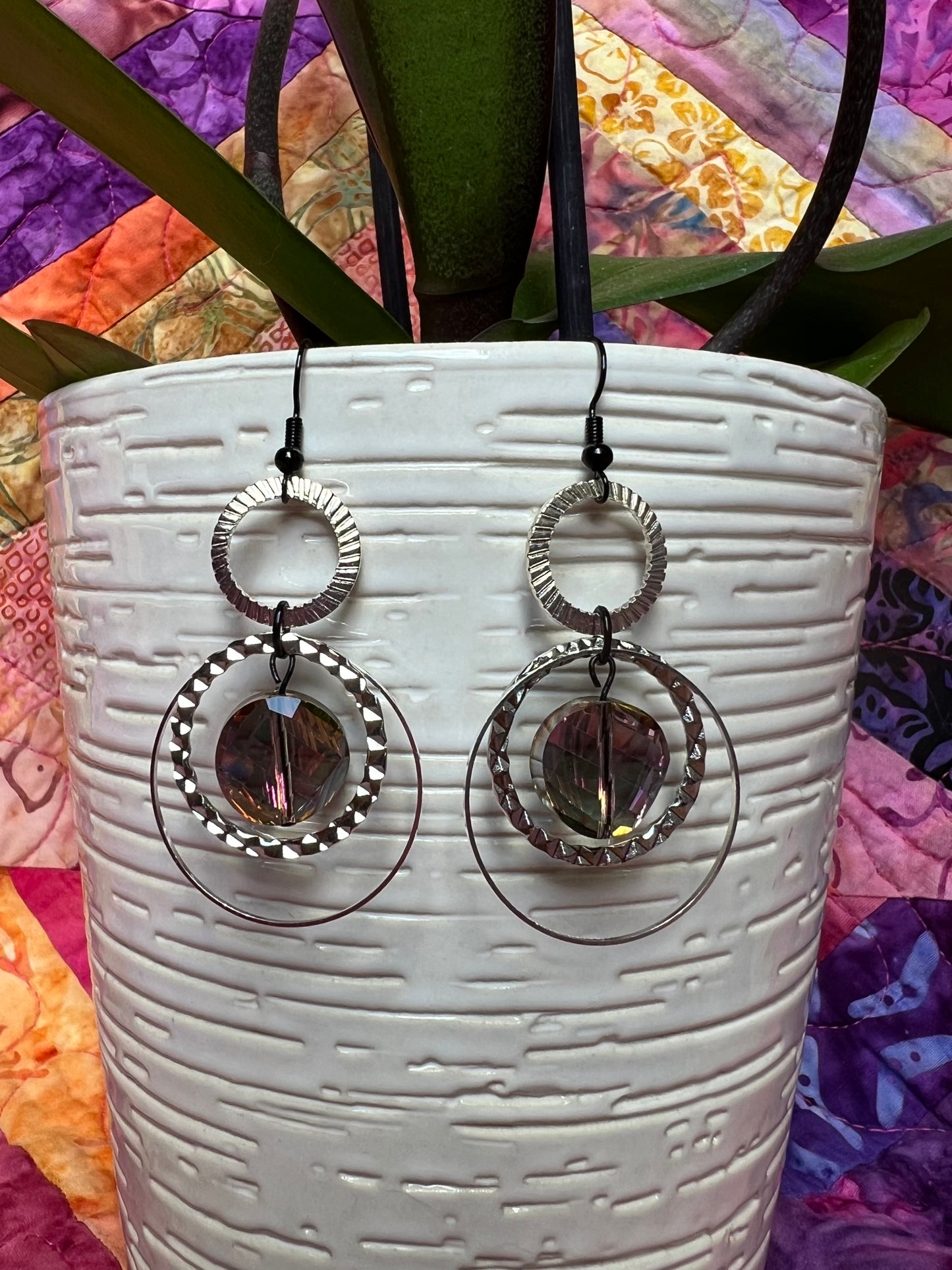 Earrings- Silver plated metal hoops and black plated wires with iridescent coin crystals.