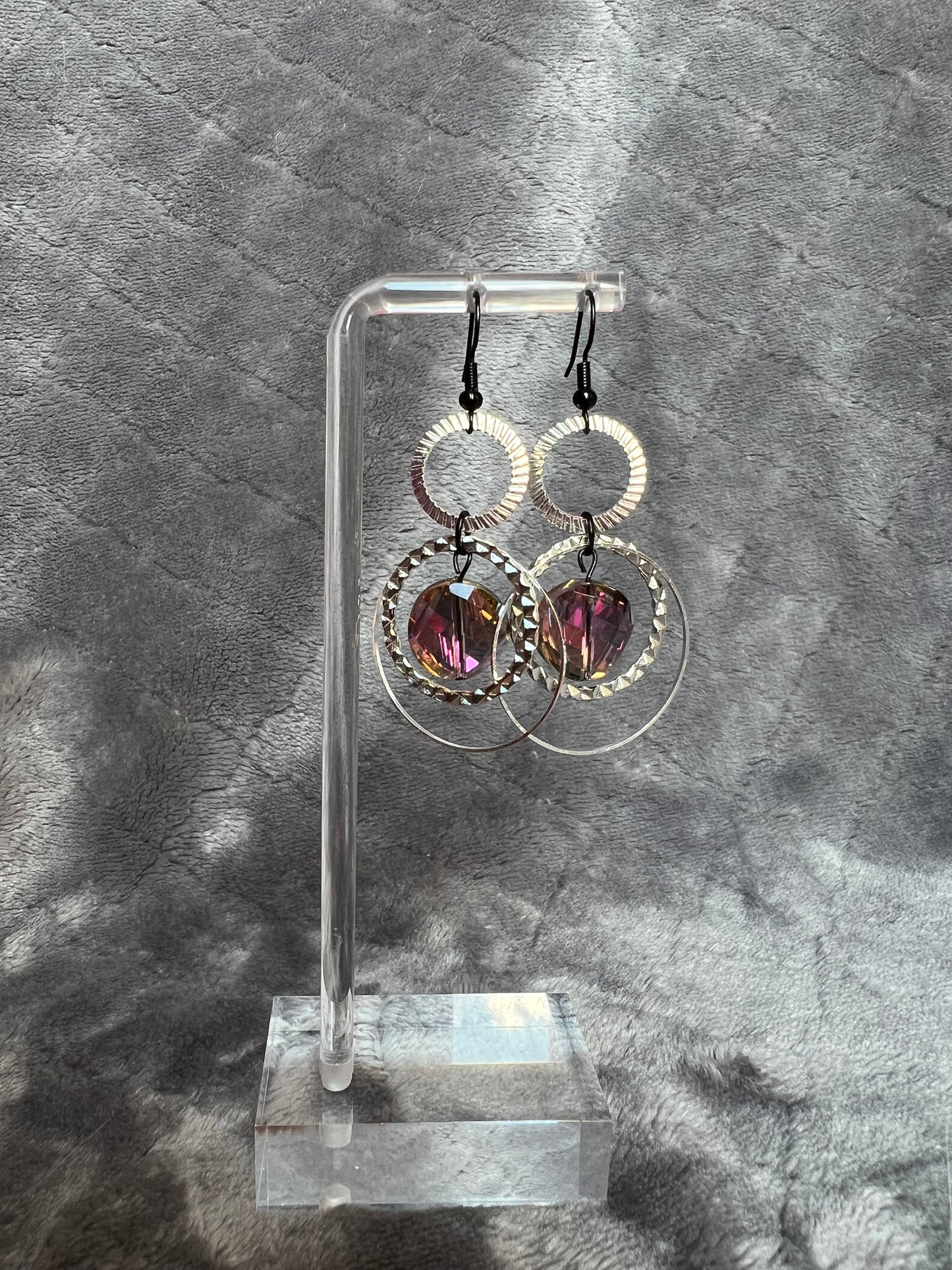 Earrings- Silver plated metal hoops and black plated wires with iridescent coin crystals.