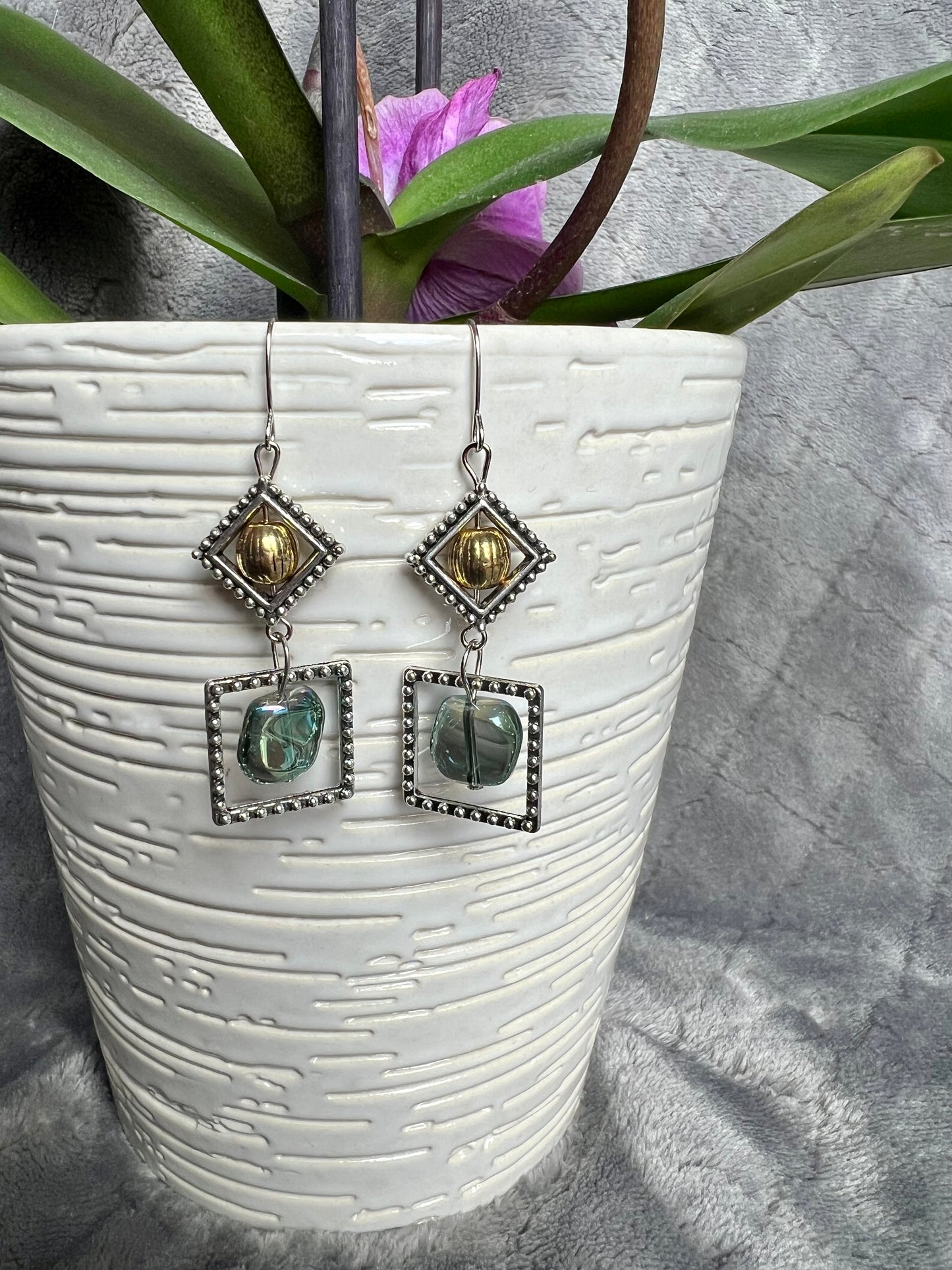 Earrings- Silver plated hooks with antique silver plated metal, round bead, and blue/green glass bead dangle.