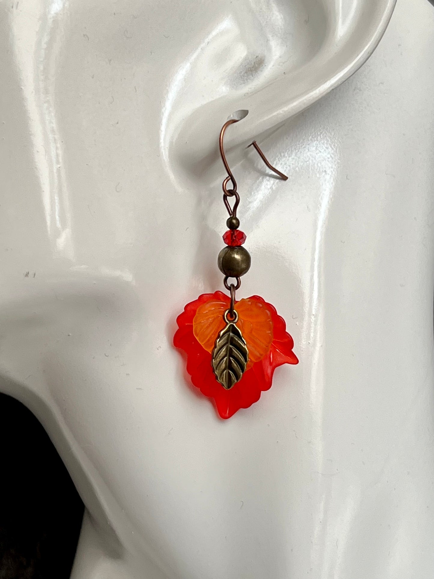 Earrings- Antique copper plated ear wires, antique gold leaf charms, red and orange lucite leaves.