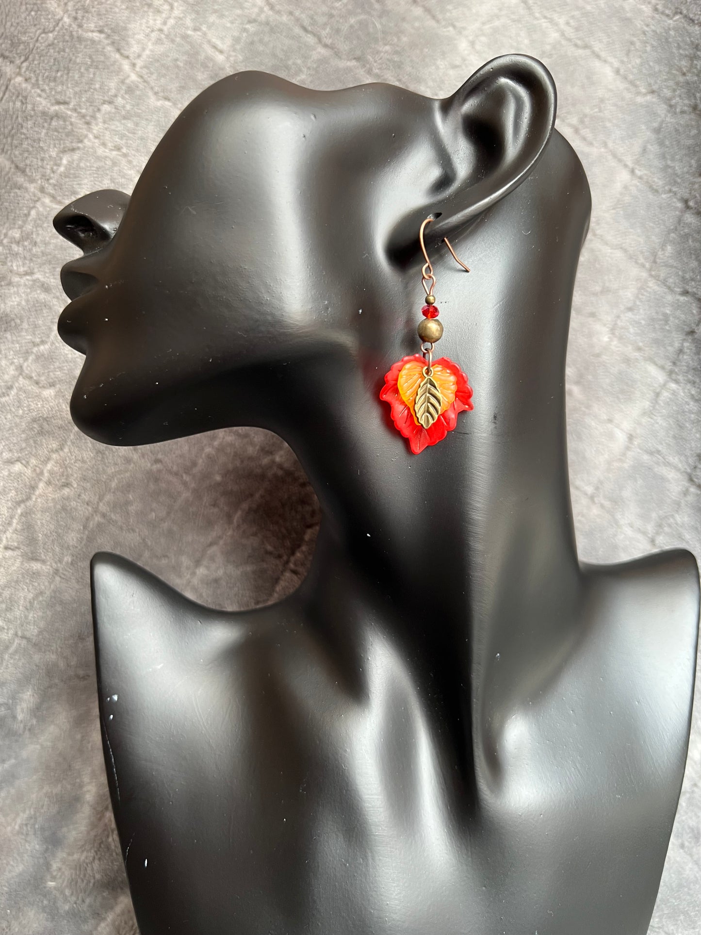 Earrings- Antique copper plated ear wires, antique gold leaf charms, red and orange lucite leaves.