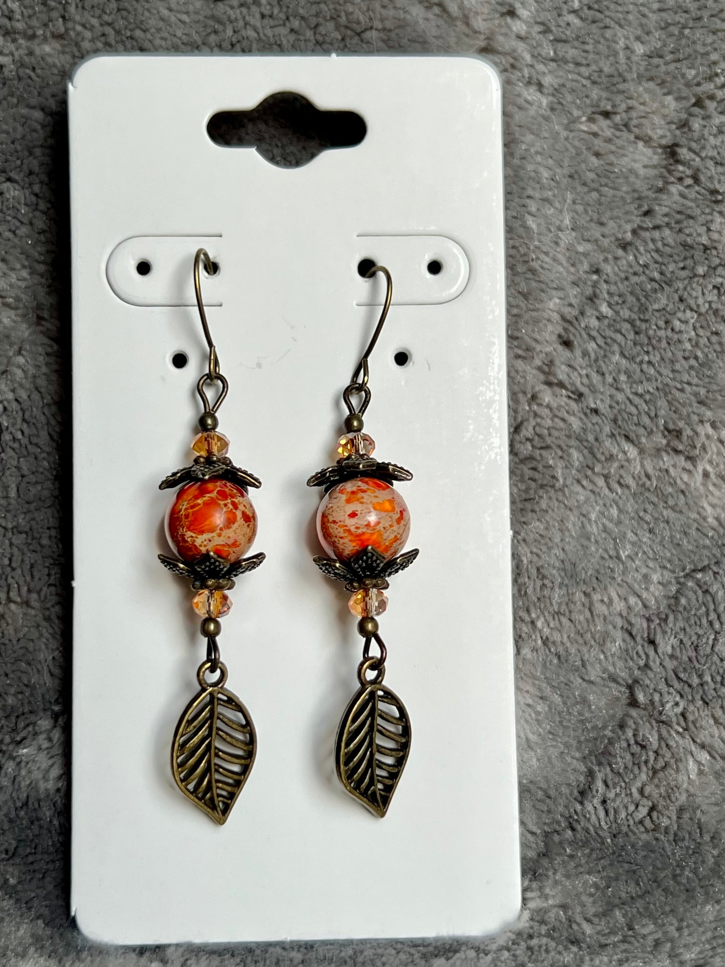 Earrings- Antique gold plated ear wires and metal leaves, small yellow orange crystal beads and natural dyed stone round beads.