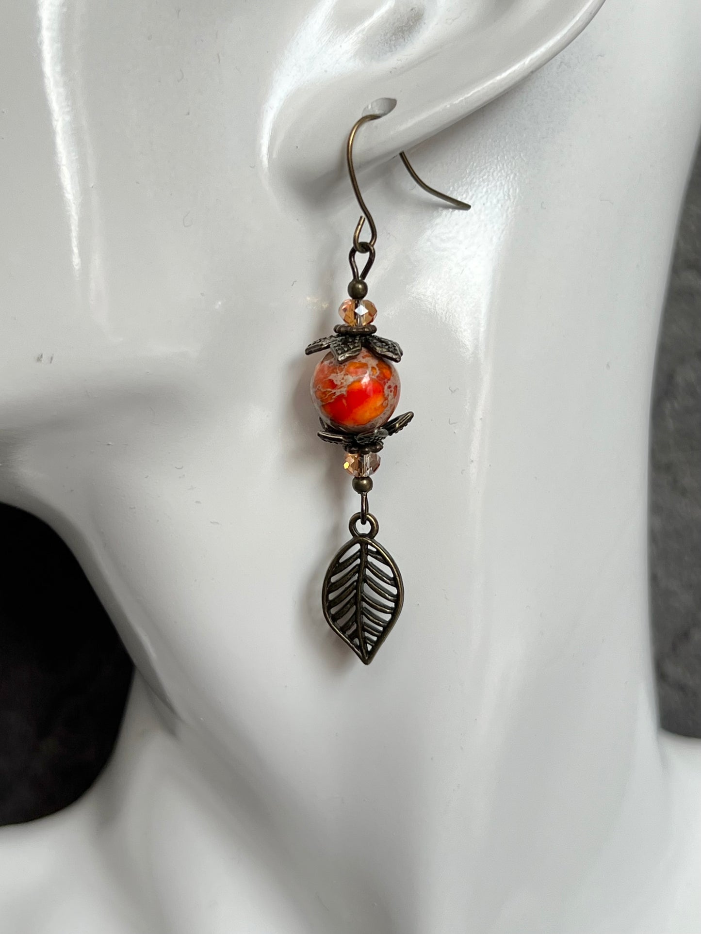 Earrings- Antique gold plated ear wires and metal leaves, small yellow orange crystal beads and natural dyed stone round beads.