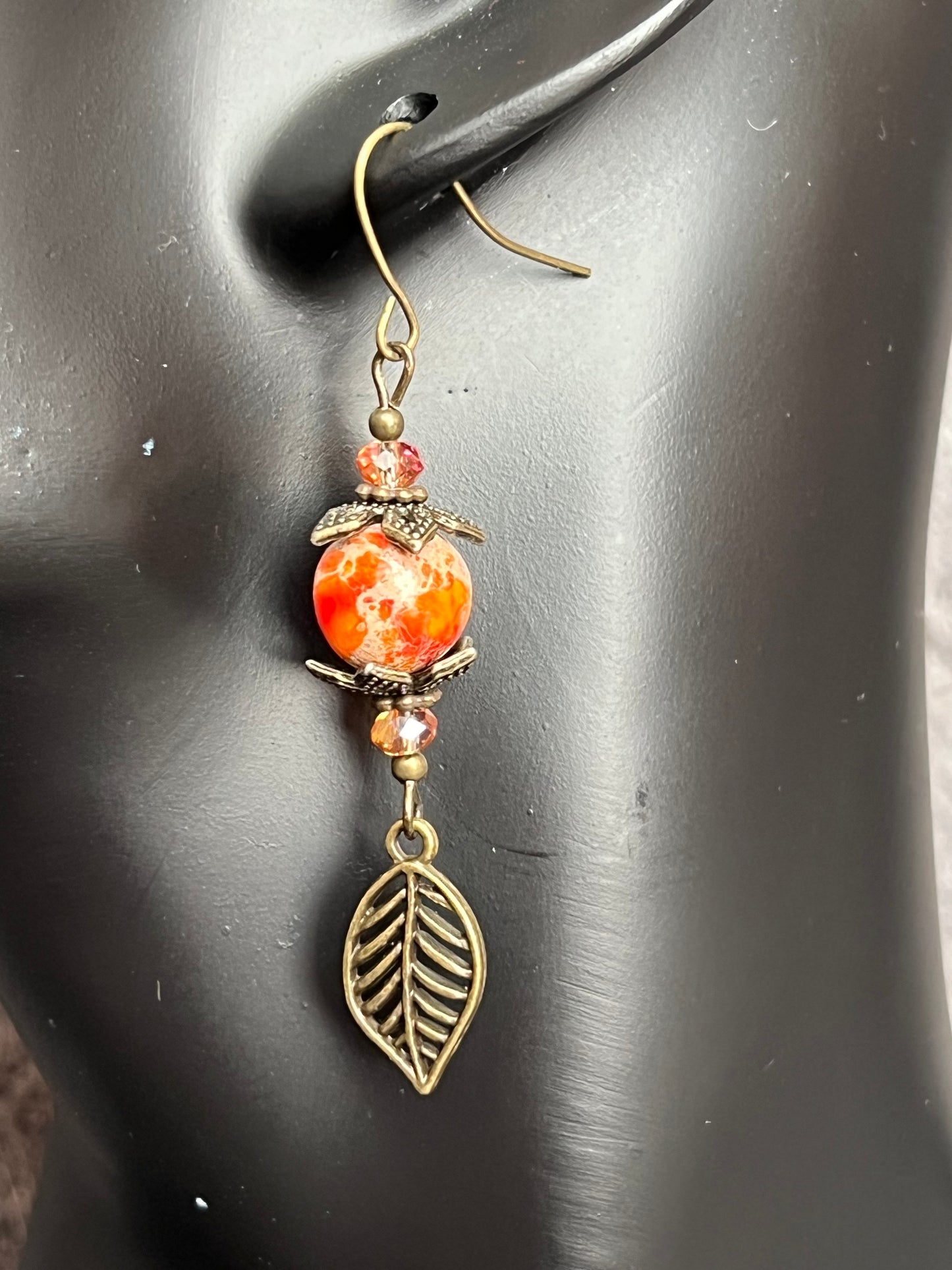 Earrings- Antique gold plated ear wires and metal leaves, small yellow orange crystal beads and natural dyed stone round beads.