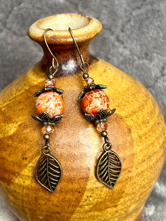 Earrings- Antique gold plated ear wires and metal leaves, small yellow orange crystal beads and natural dyed stone round beads.