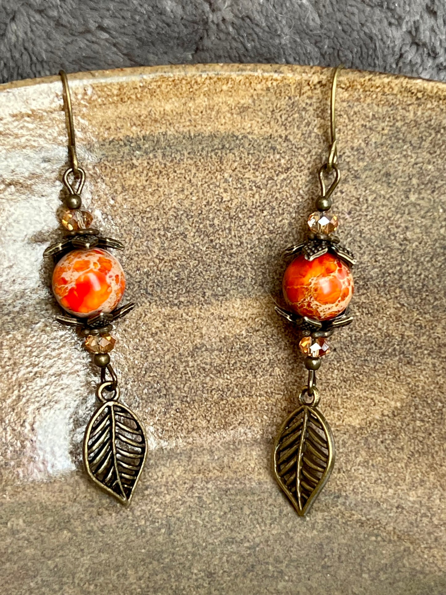 Earrings- Antique gold plated ear wires and metal leaves, small yellow orange crystal beads and natural dyed stone round beads.