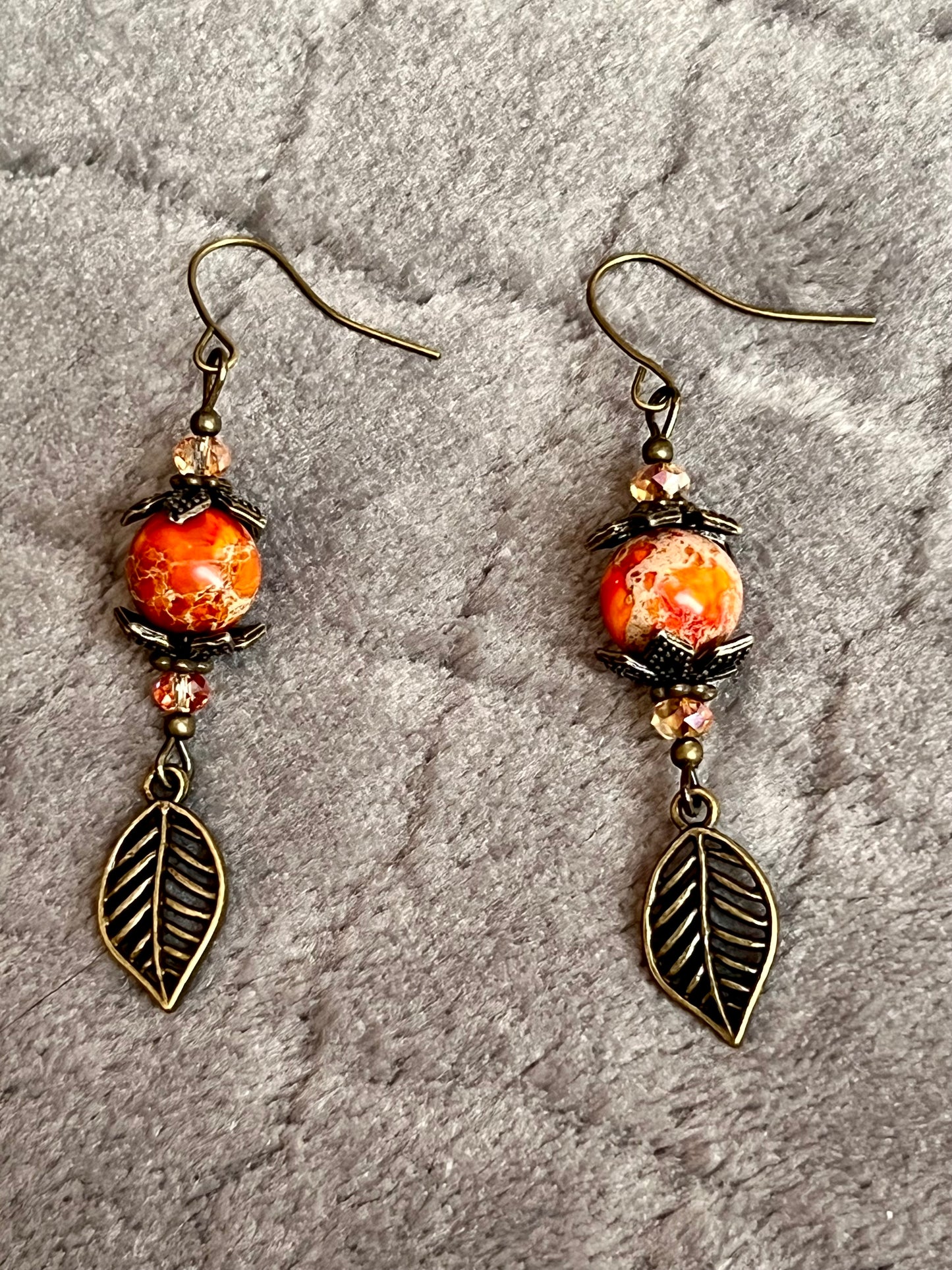 Earrings- Antique gold plated ear wires and metal leaves, small yellow orange crystal beads and natural dyed stone round beads.