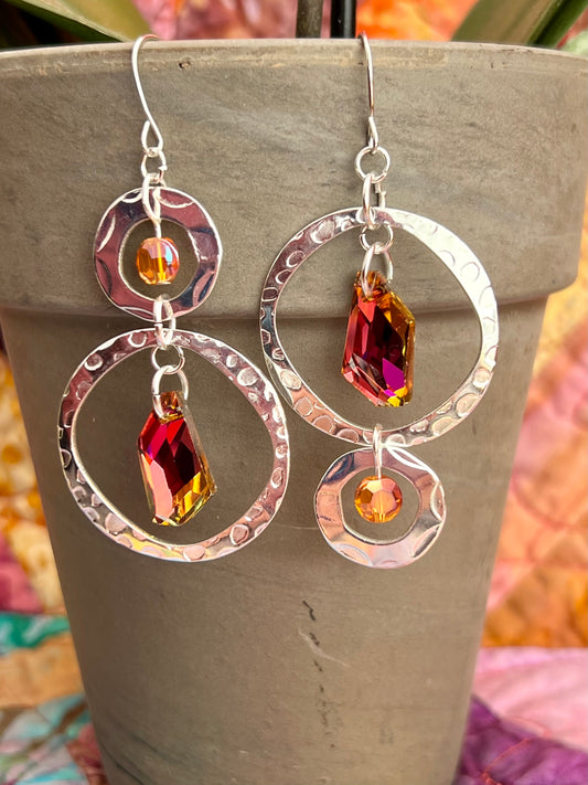 Earrings- Asymmetrical silver plated metal with orange/copper AB and foil backed magenta crystals.