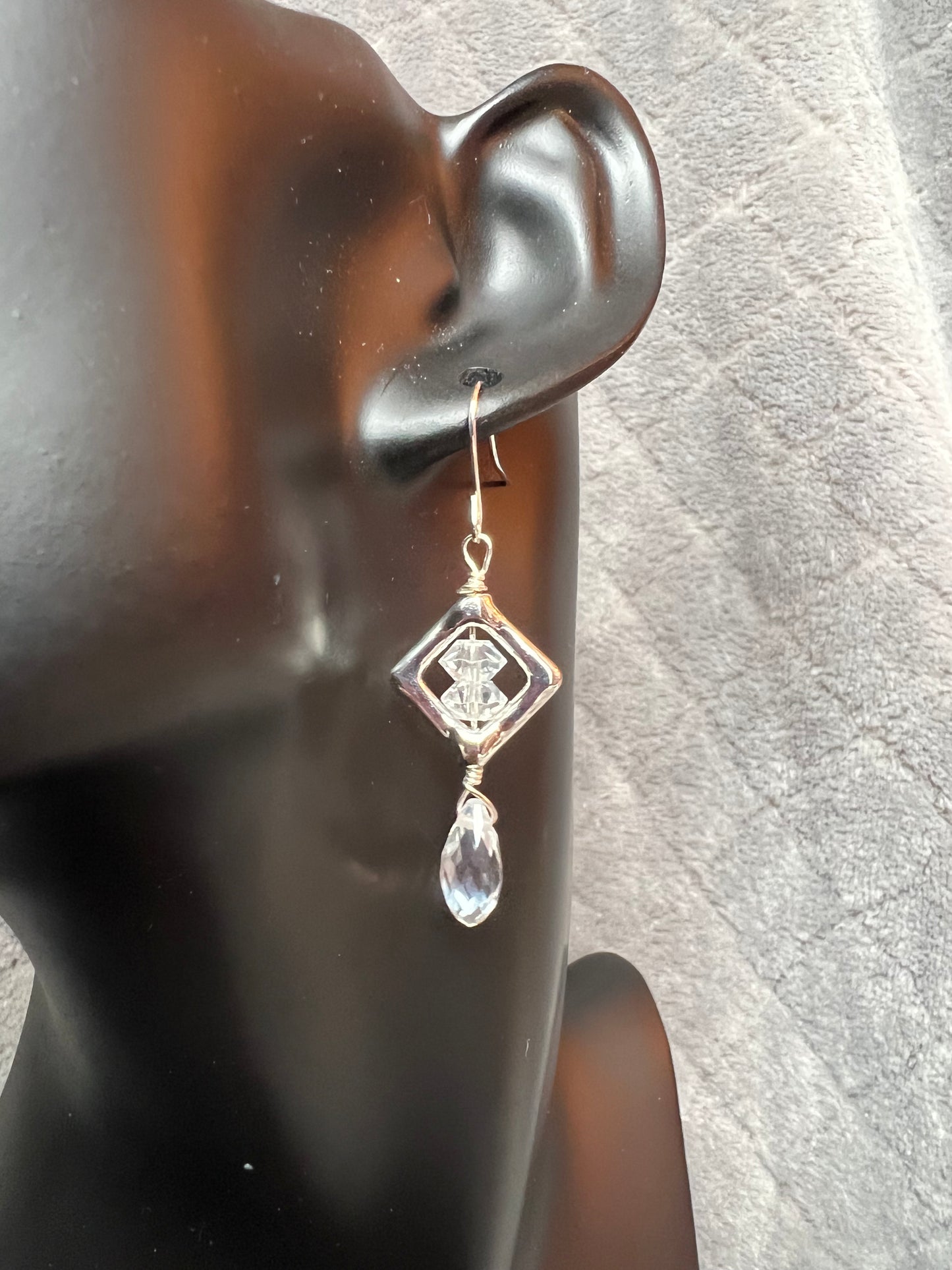 Earrings- Silver plated metal with diamond shaped bead frames and clear crystals.