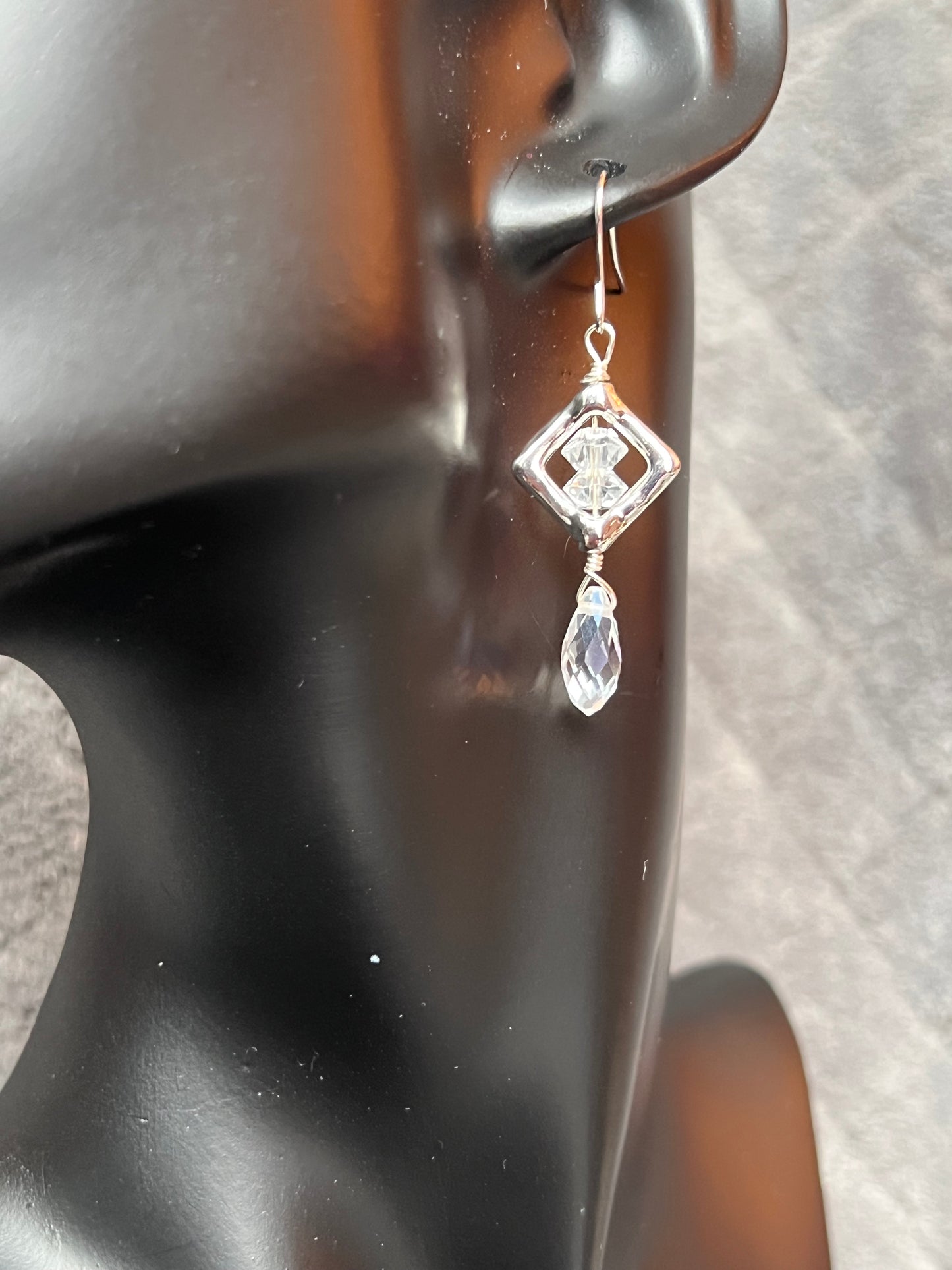 Earrings- Silver plated metal with diamond shaped bead frames and clear crystals.