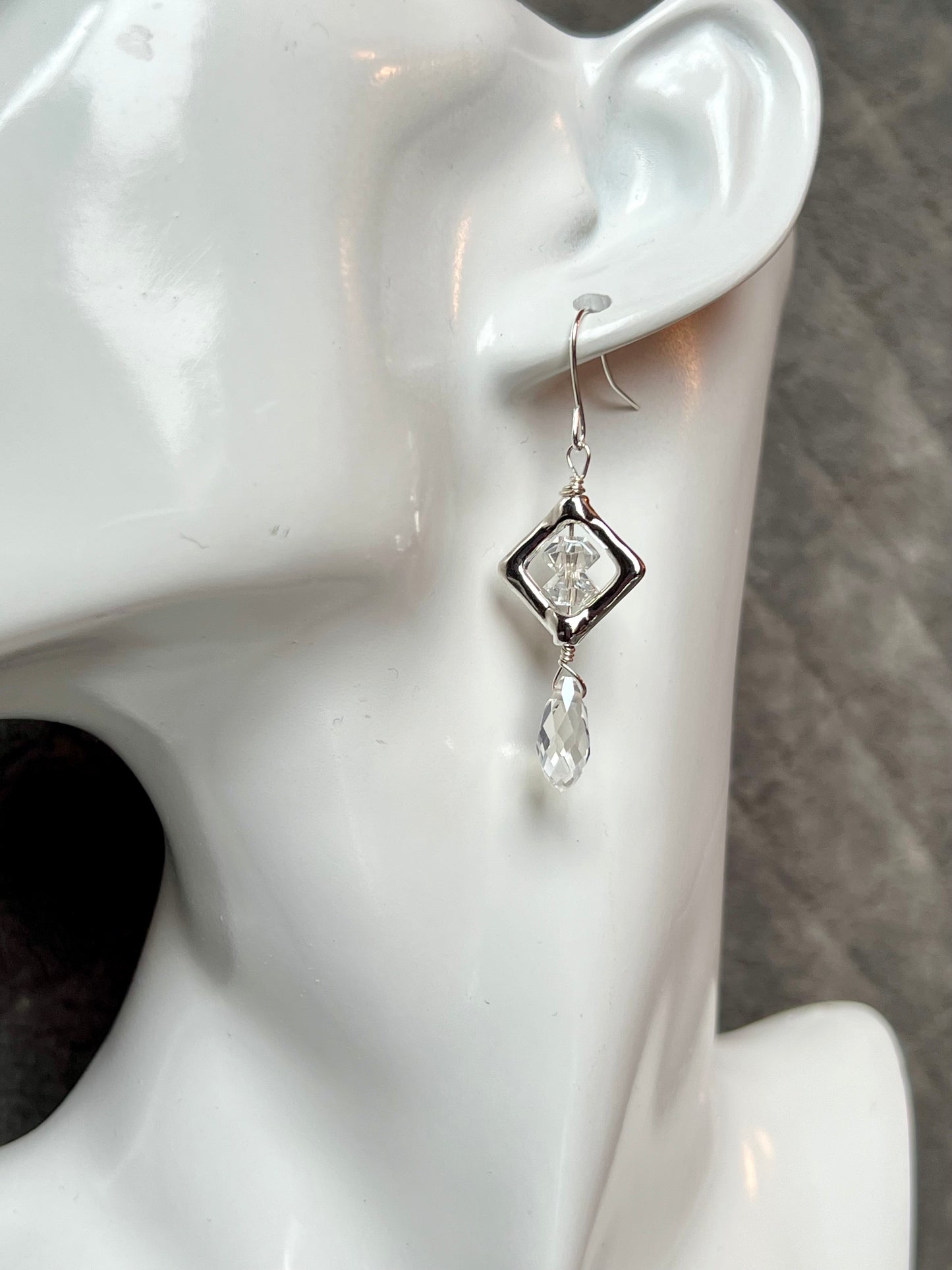 Earrings- Silver plated metal with diamond shaped bead frames and clear crystals.