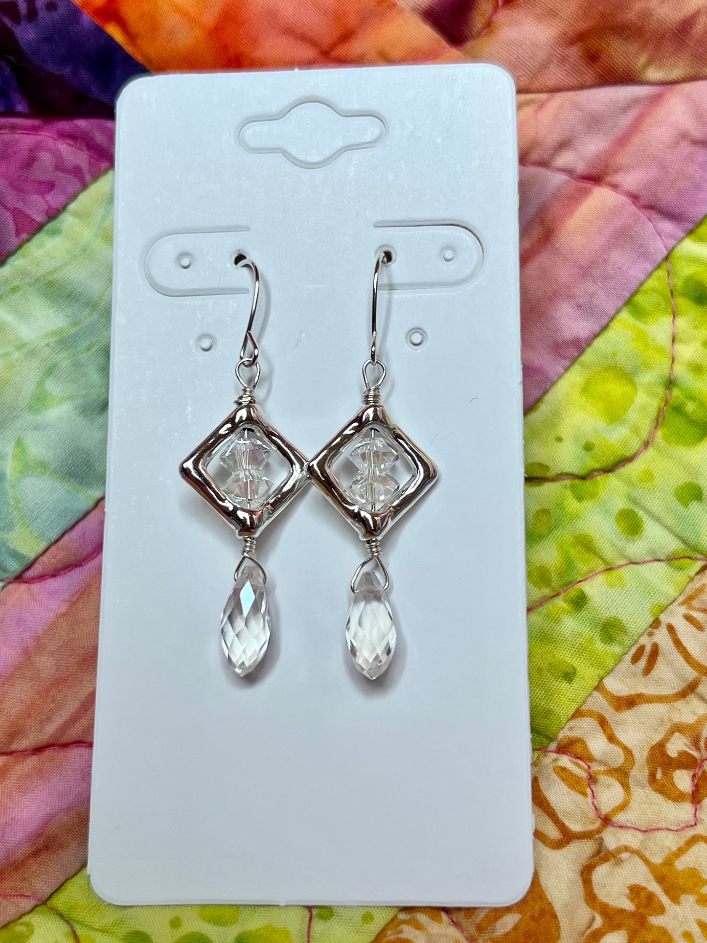 Earrings- Silver plated metal with diamond shaped bead frames and clear crystals.